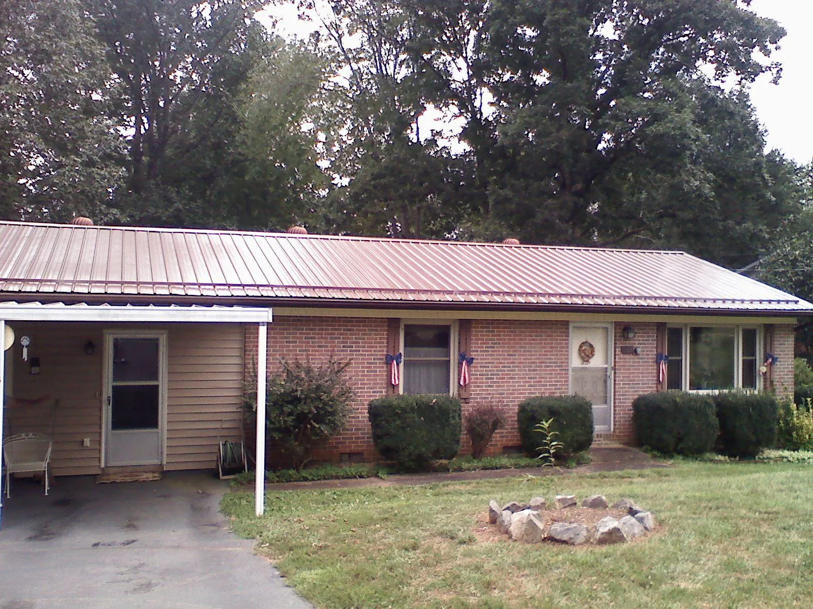 Bronze metal roof and carport on a brick ranch home — Roof Repair work by our crew in Elgin